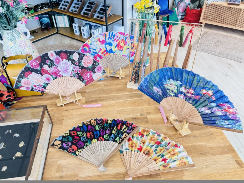 Collection d’éventails colorés exposés dans une boutique d’optique.